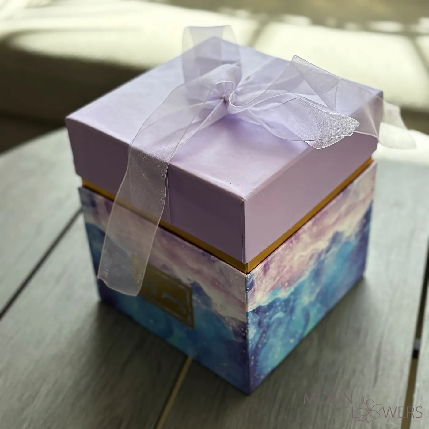 A box with multicolored gypsophila, J.P. CHENET Grenache Cinsault Rosé Sec 0.25L, and macarons