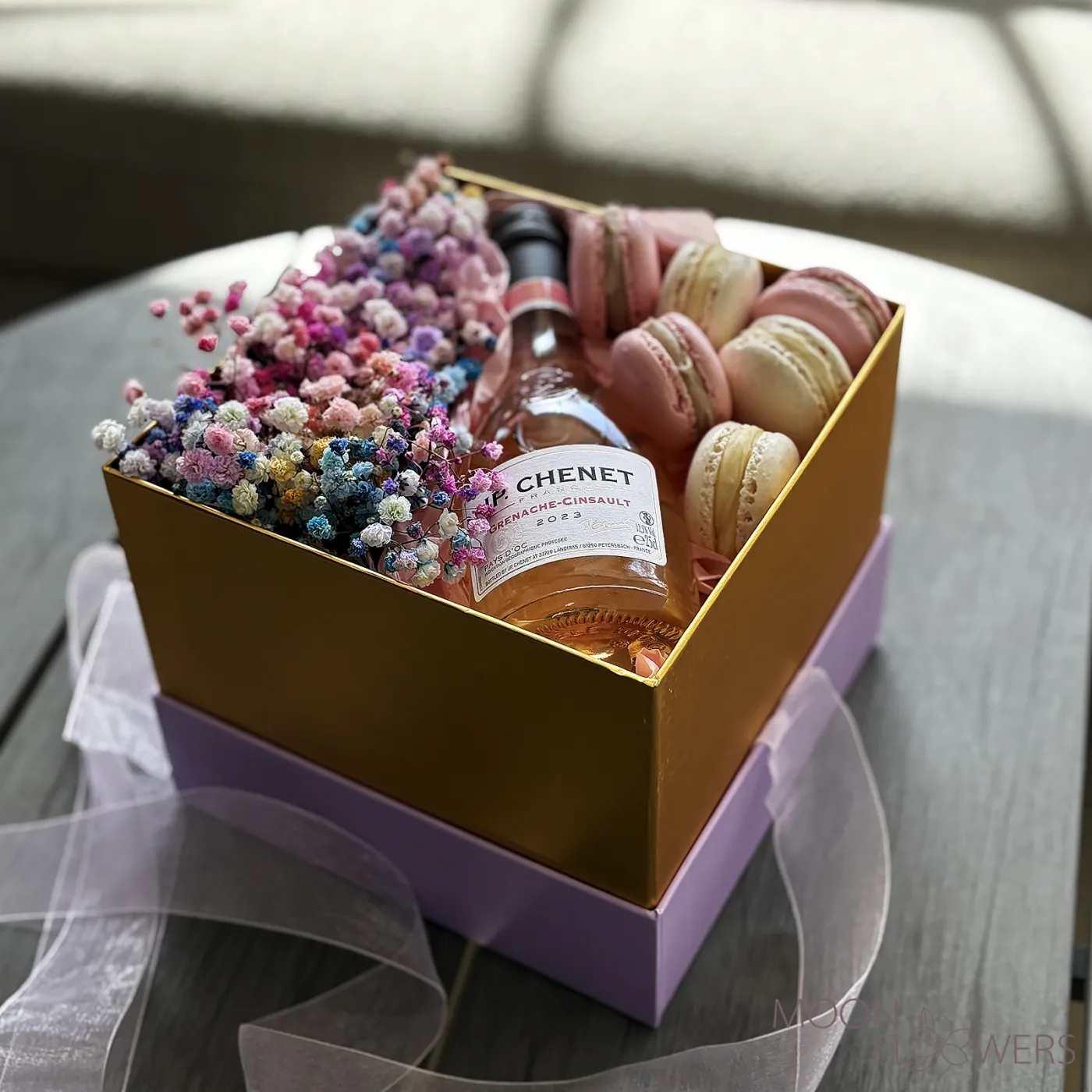 A box with multicolored gypsophila, J.P. CHENET Grenache Cinsault Rosé Sec 0.25L, and macarons