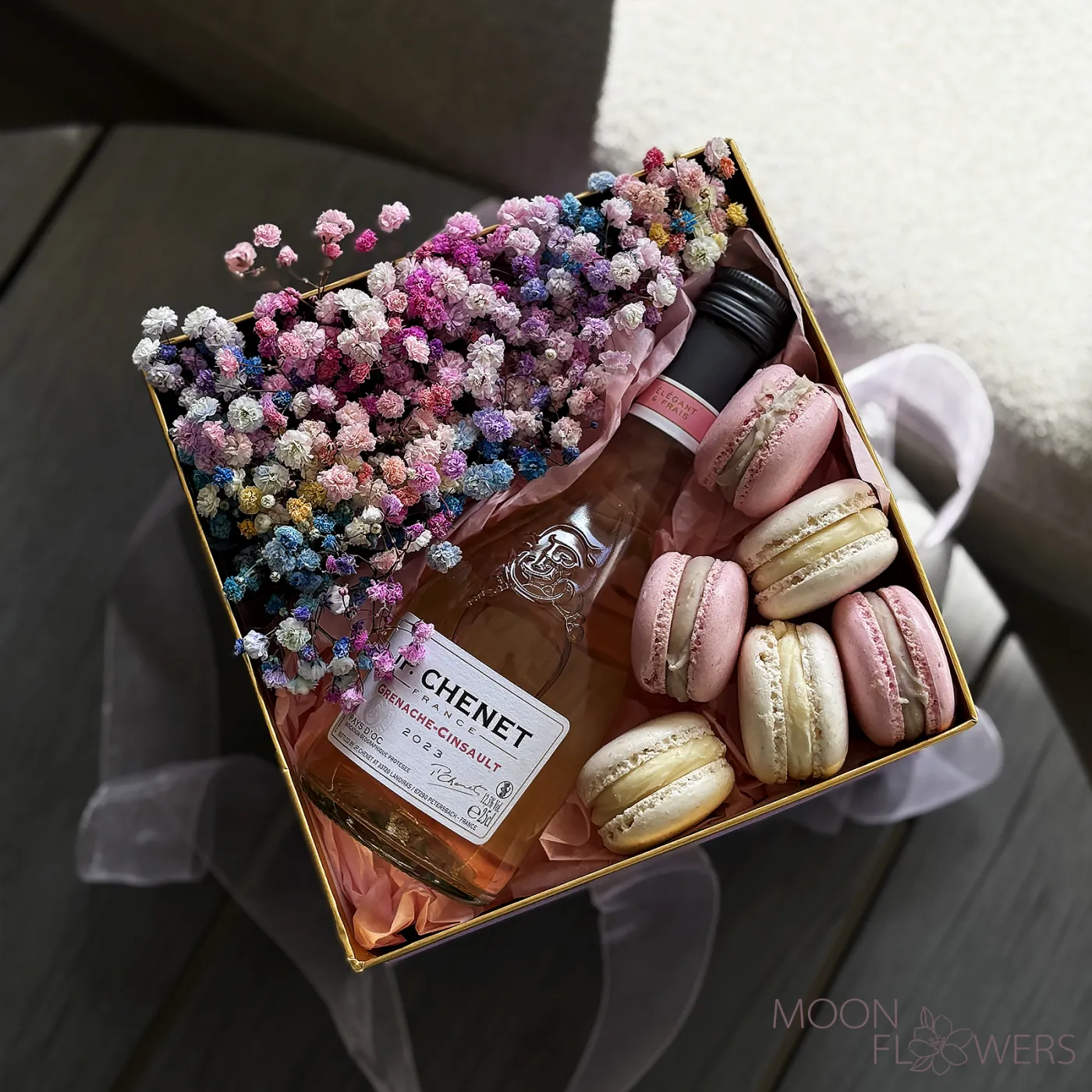 A box with multicolored gypsophila, J.P. CHENET Grenache Cinsault Rosé Sec 0.25L, and macarons